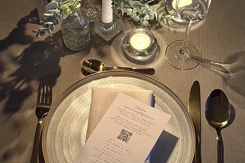 婚宴餐桌上，餐盘里放着印有二维码的席位卡。